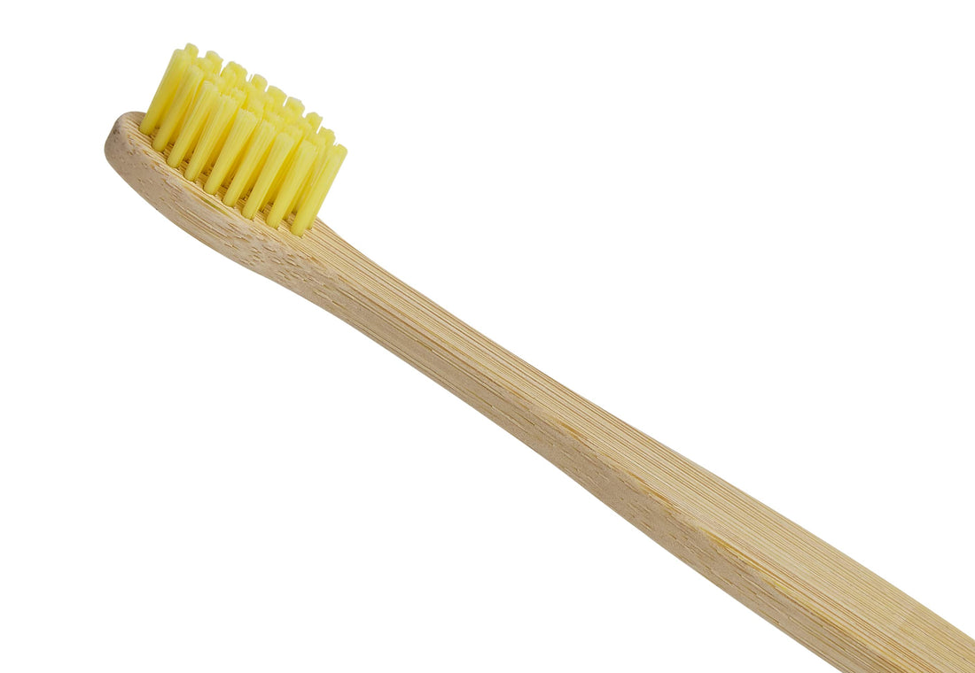 Close up of yellow bristles on a bamboo toothbrush